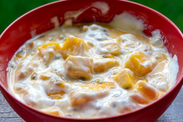 Mango maracuyá y yogurt brulée Postre de frutas en el desayuno con gajos de mangos perfectamente maduros en temporada cubiertos con pulpa fresca de maracuyá