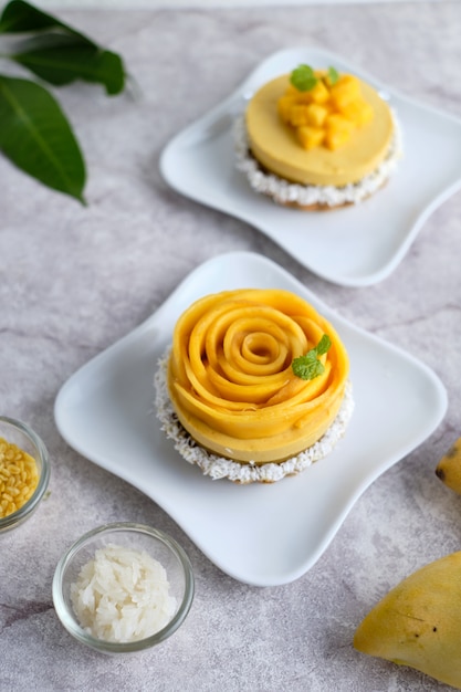 Mango-Mousse-Torte mit Klebreis und frischer Mango. auf weißen Cafe Tisch gesetzt.