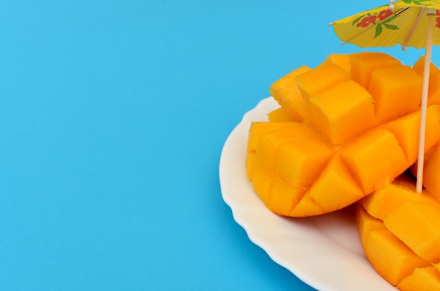 Mango en rodajas servido en un plato blanco sobre fondo de colores