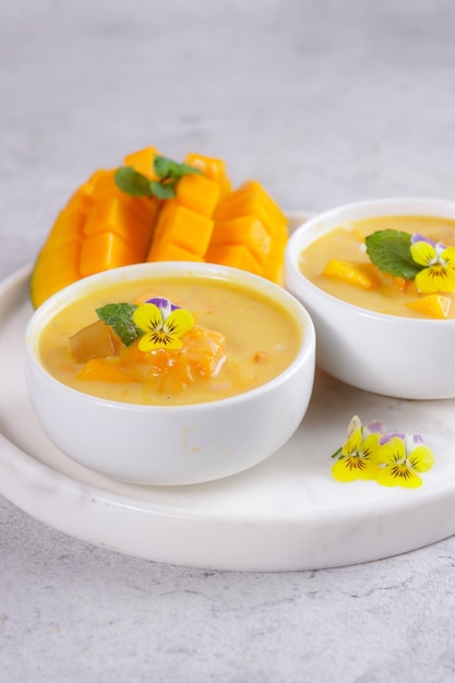 Mango sagú Crema de sagú dulce con leche de coco de mango y jugo de mango guarnición con flores comestibles