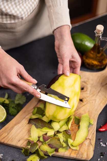 Mango-Salsa kochen, Frau schält Mango-Frucht