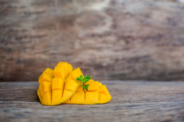 Mangofrucht und Mangowürfel auf dem Holztisch.