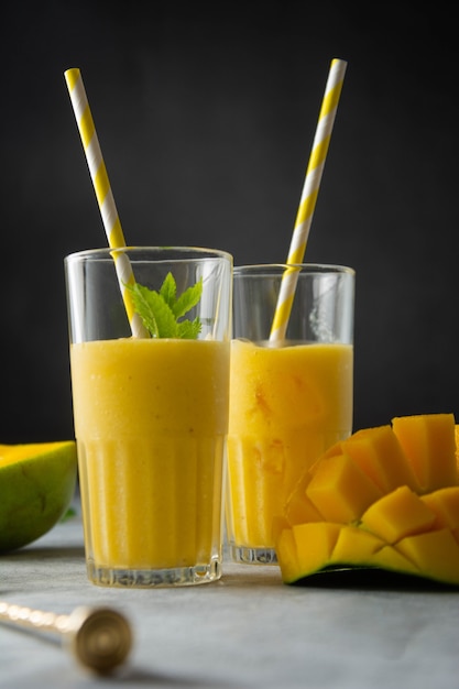 Mangosaft im Glas mit frischen Mangoobst und Minzblättern