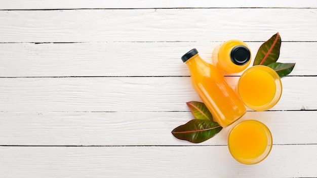 Mangosaft Orange Ananas in das Glas Auf einem hölzernen Hintergrund Tropische Früchte Ansicht von oben Kostenloser Kopierbereich