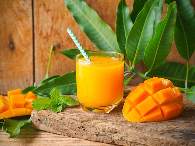 Mangosaft serviert mit frischer, reifer Mango, geschnitten für Sommergetränkekonzept