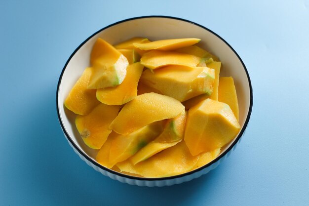 Foto mangoscheiben auf einem weißen salatteller auf hellblauem hintergrund