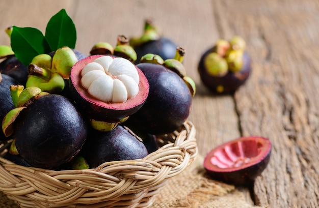 Mangostán fresco en cesta de bambú y en madera vieja baclground Reina de las frutas concepto de frutas de asia