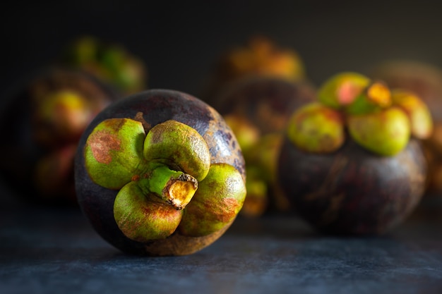 Mangostanfrucht auf schwarzem Zementboden und Morgenlicht.