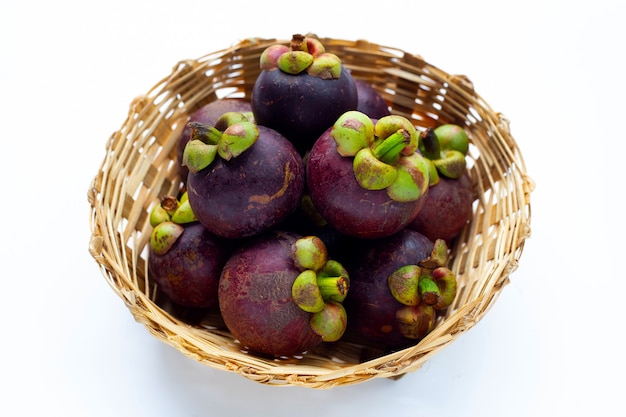 Mangostanfrucht im Bambuskorb auf weißem Hintergrund.