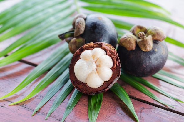 Mangostine auf einem frischen grünen Blatt