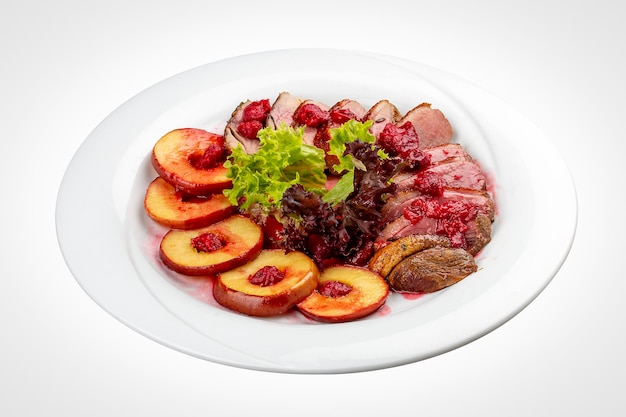 Foto mangre de pechuga de pato con bayas confitadas y manzana al horno sobre un fondo blanco