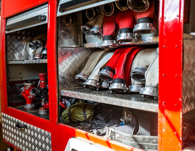 Foto mangueiras de incêndio enroladas dispostas em fileiras no porta-luvas do caminhão de bombeiros