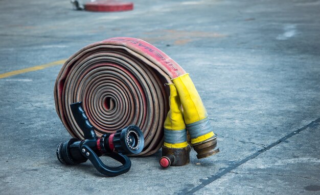 Manguera contra incendios y boquilla en el suelo