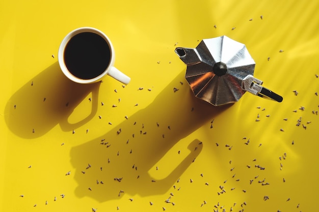 manhã com uma xícara de café quente, croissant doce e buquê de lavanda em fundo amarelo. Vista do topo