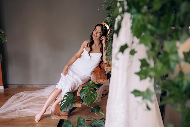 Manhã da noiva linda morena no dia do casamento vai para a saída do altar em um lindo roupão