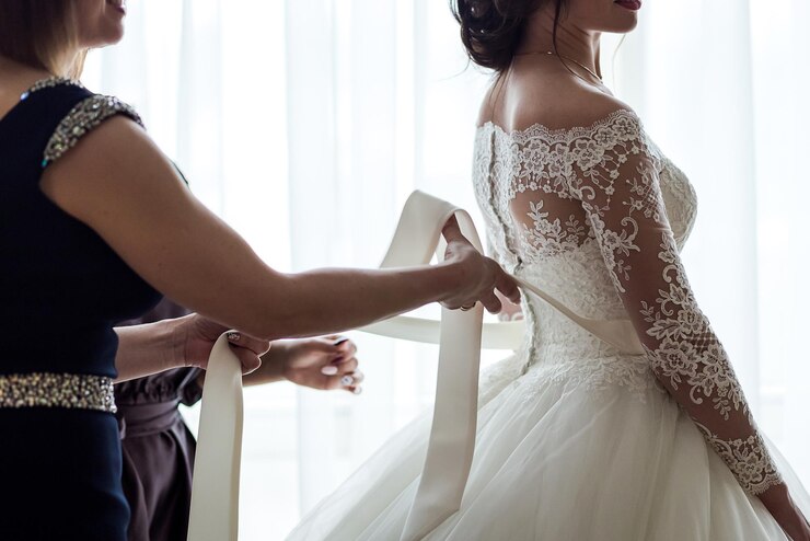 Manhã da noiva quando ela usa um lindo vestido mulher se preparando antes da cerimônia de casamento