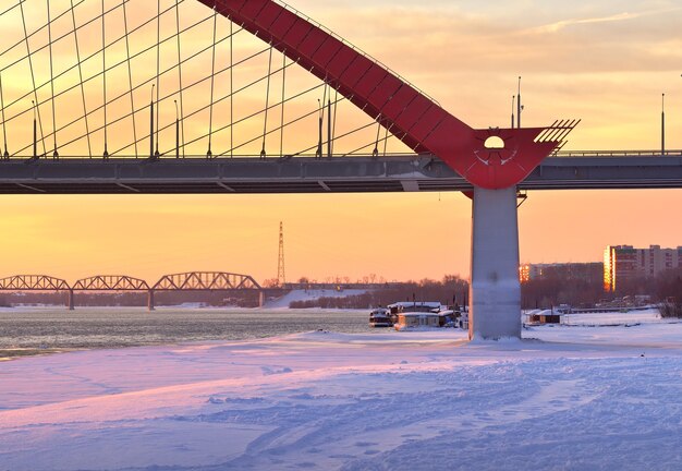 Manhã de inverno no automóvel Ob Bugrinsky e nas pontes da ferrovia Komsomolsky no rio congelado