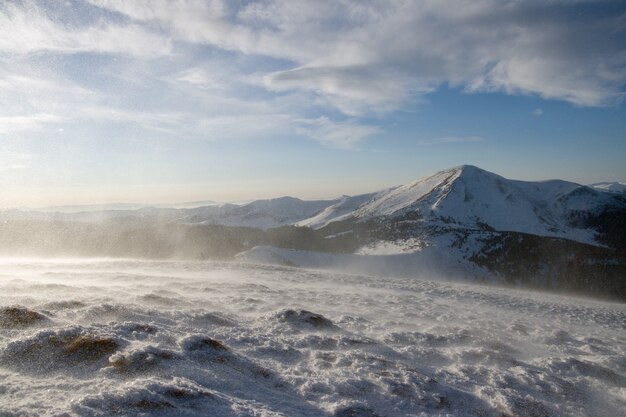 Manhã de inverno paisagem montanhosa com forte tempestade de vento e neve