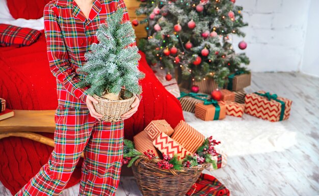 Manhã de Natal, menina com presentes nas mãos. Foco seletivo. Feriado.