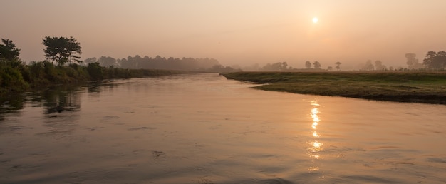 Manhã de nevoeiro em um rio no Parque Nacional Royal Chitwan, Nepal