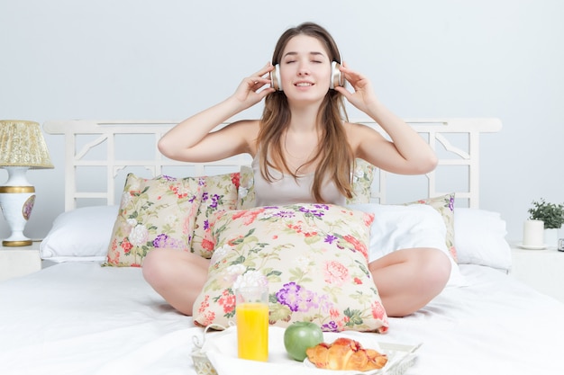 Manhã e café da manhã de uma linda jovem na cama em casa