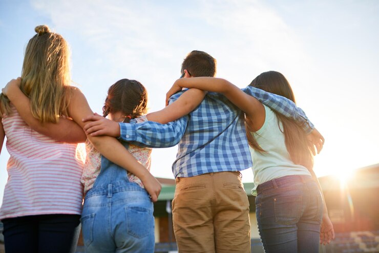 Foto manhã e costas de crianças no parque para apoio amizade e ligação ao ar livre diversidade jovens e grupo de crianças abraçar para a escola da comunidade de aprendizagem e desenvolvimento junto com o sol