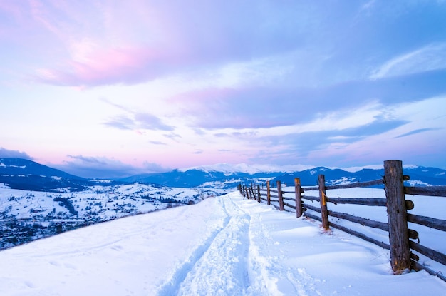 Foto manhã fria, bela paisagem de montanhas cobertas de neve, nascer do sol mágico de inverno em um pico de colina