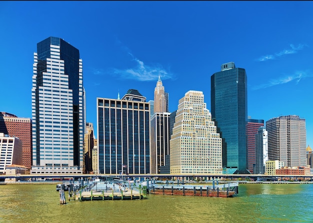Manhattan Downtown Panorama über den East River mit städtischen Wolkenkratzern und blauem Himmel in New York City, USA