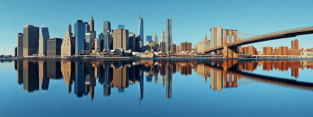 Manhattan Financial District mit Wolkenkratzern und Brooklyn Bridge mit Reflexionen.