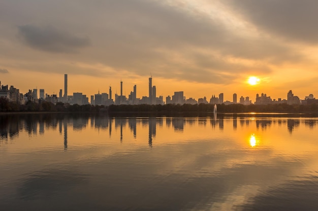 Manhattan Skyline und Reflexion im Jacqueline Kennedy Onassis Reservoir im Central Park bei sonnigem Sonnenuntergang. New York City