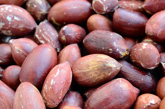 Maní. Un montón de pequeñas nueces amarillas con cáscara marrón. Textura de fondo