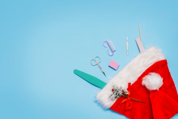 Manicura en un gorro de Papá Noel rojo sobre un azul