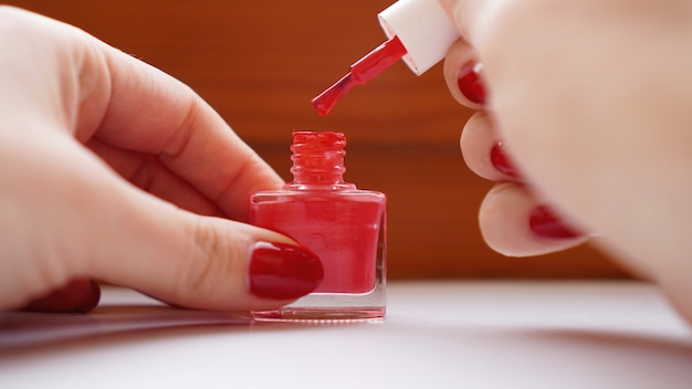 Manicura - Hermosas uñas de mujer cuidadas con esmalte de uñas rojo