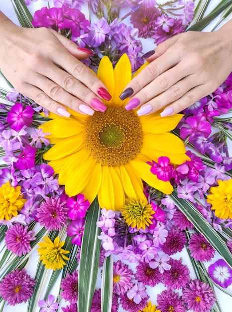 Manicura larga multicolor con una composición de flores.