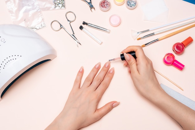 Manicura. Una niña se pinta las uñas. Manos cerca