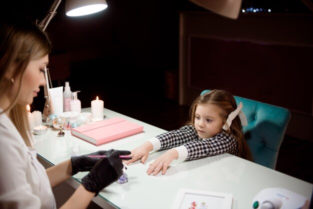 Manicura para niña en un salón de belleza.