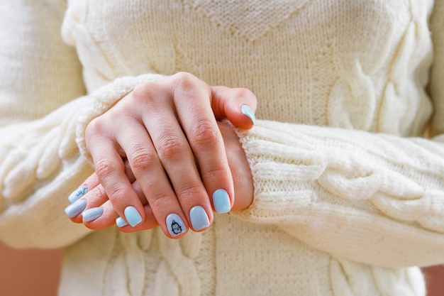 Manicura pastel suave para una niña sobre un fondo de ropa