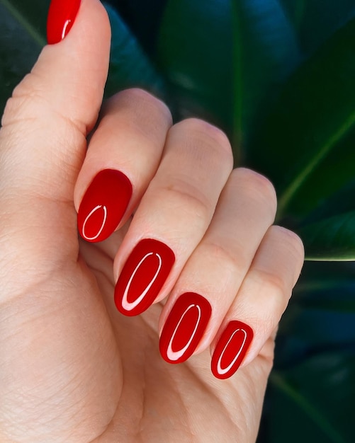 Manicura roja festiva brillante en manos femeninas Diseño de uñas