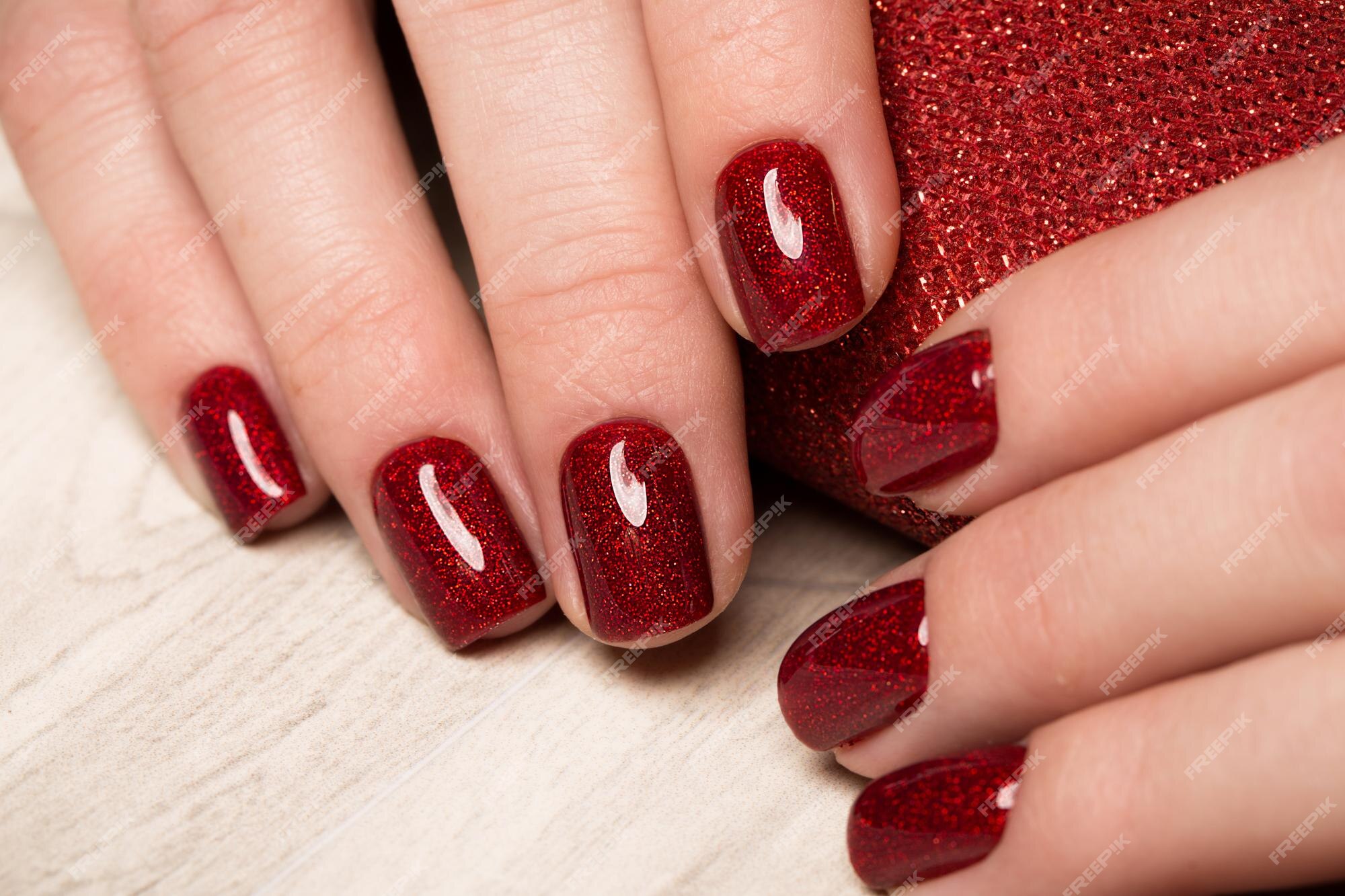 Manicura roja festiva brillante en manos femeninas. diseño de uñas. | Foto  Premium