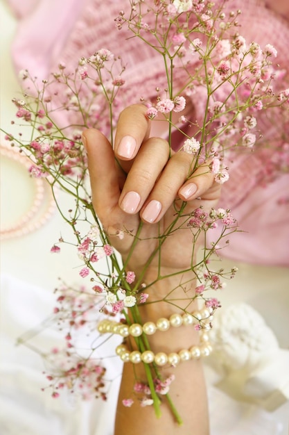 Manicura rosa en uñas cortas.