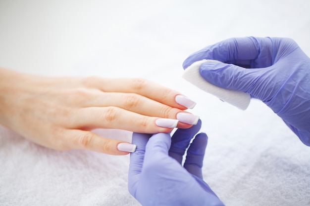 Manicura SPA. Mujer en un salón de uñas recibiendo una manicura por una esteticista