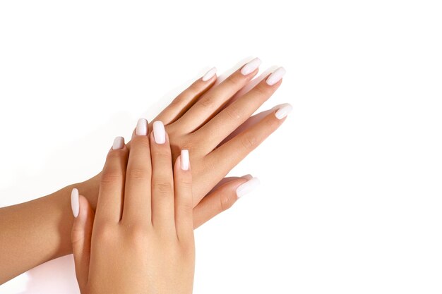 Foto manicure con uñas blancas sobre un fondo blanco