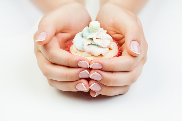 Manicure francesa unhas bem cuidadas e cupcake no fundo branco