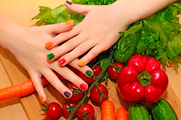Manicure infantil com design de verniz colorido para as unhas na menina com pepino, tomate, cenoura, berinjela de alimentos diferentes.