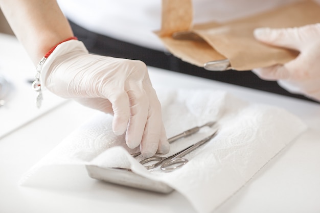 Manicure limpando seu lugar para atender um novo cliente. mesa de salão esterilizante para prevenir infecções.