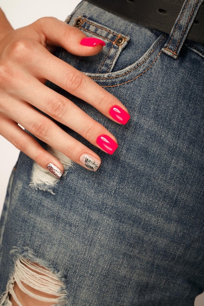 Foto manicure neon brilhante nas mãos femininas no fundo do jeans design de unhas mãos de beleza