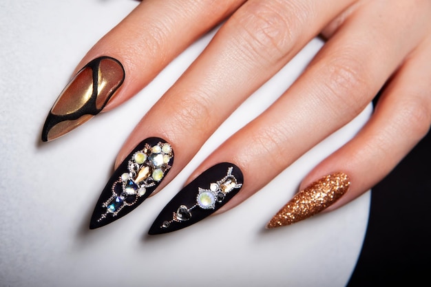 Foto manicure preta e dourada com diamantes