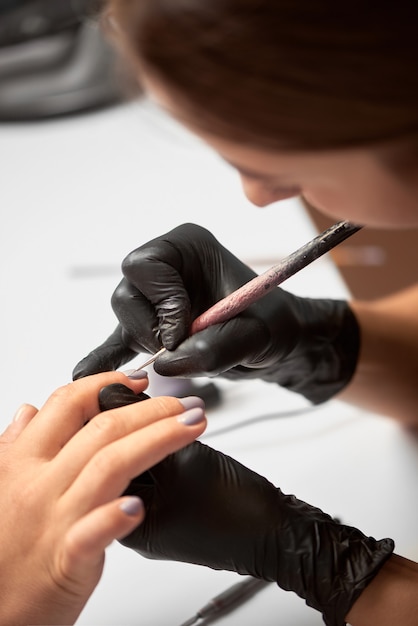 Manicure profissional mestre trabalhando nas unhas dos clientes
