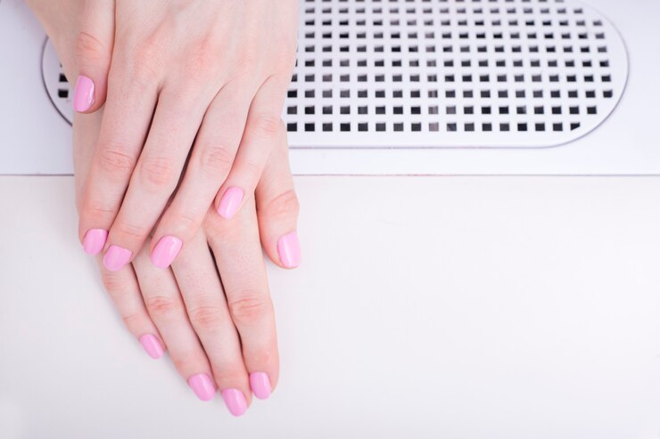 Foto manicure rosa suave. mãos femininas em salão de manicure
