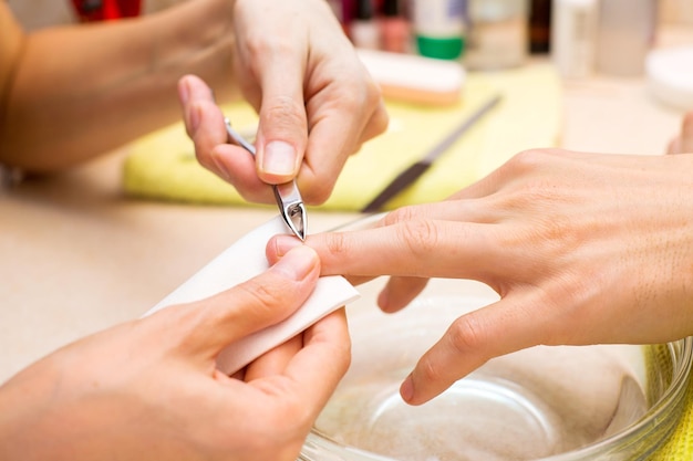 Manicures profissionais fazem manicure para um homem no salão de beleza